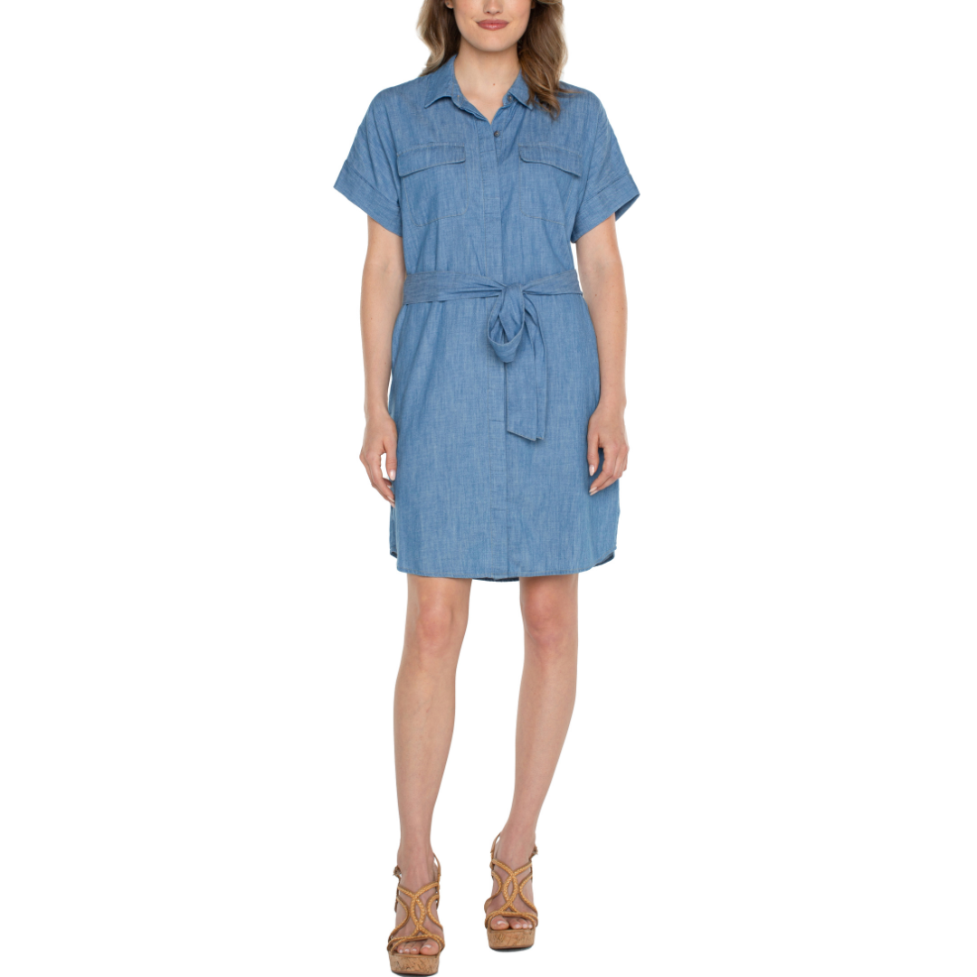 Hannahs Boutique -Erin Ontario - Liverpool Belted Shirt Dress in Chambray Blue: a timeless and versatile option, Smooth indigo twill cotton  material for classic elegance. Self-tie belt for personalized fit; belt-free option for relaxed look, Hidden button front closure for seamless style. Short sleeves with fold detail add a chic touch. Side seam pockets and two front flap pockets for convenience. Made from 100% cotton for comfort.