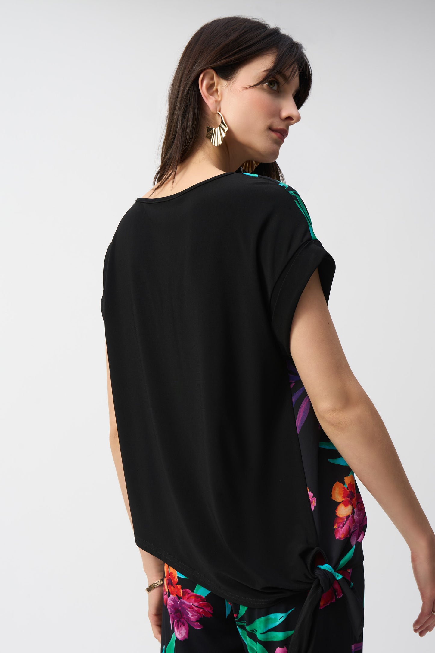 Hannahs of Erin-Erin Ontario-Joseph Ribkoff Floral Side-Tie Top 251214 – Bright, gorgeous floral print on a black base. Features a flattering crew neck, side tie detail, and short cap dolman sleeves. Relaxed fit design for a comfortable and effortless look. Made from a soft 96% polyester, 4% spandex blend. Perfect for summer outings and casual wear. Hip-length cut ideal for styling with skirts, shorts, or jeans.