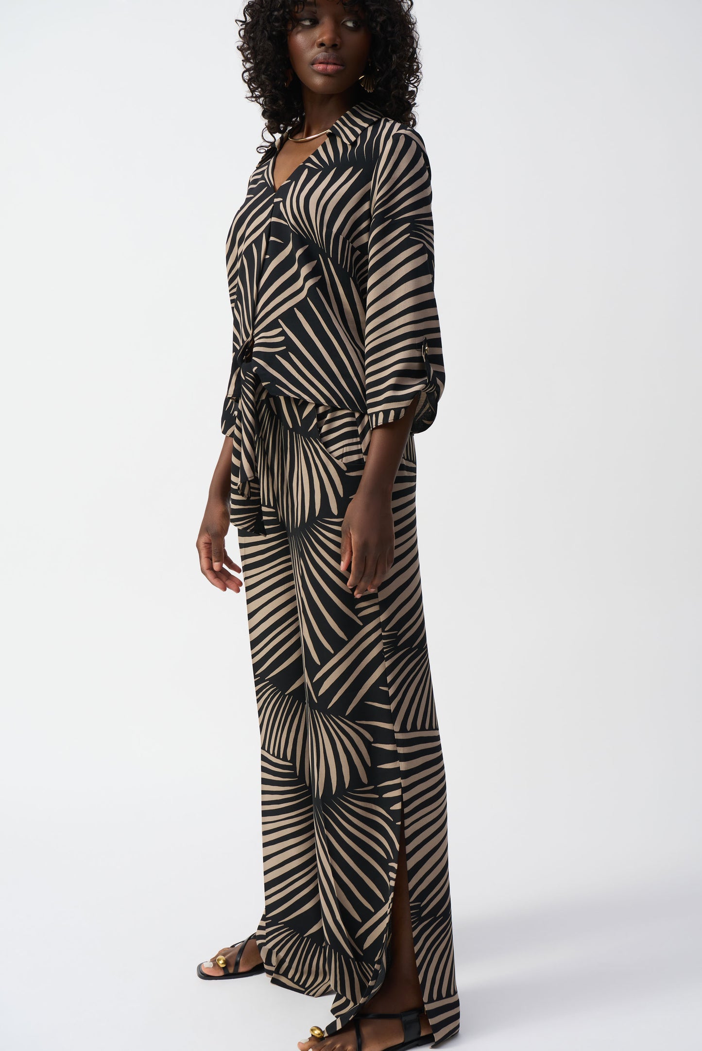 Hannahs of Erin-Erin Ontario-
Joseph Ribkoff Printed Tie-Front Blouse (Style 251083):
Bold abstract Black and camel coloured "palm" print for a modern, sophisticated look
Classic shirt collar for a polished touch
Adjustable front-tie detail for a flattering waistline, 3/4 length sleeve.
Lightweight, breathable 100% polyester fabric
Relaxed yet structured fit, suitable for all body types
Made in Canada with premium craftsmanship
Versatile styling: pair with trousers, jeans, or a pencil skirt