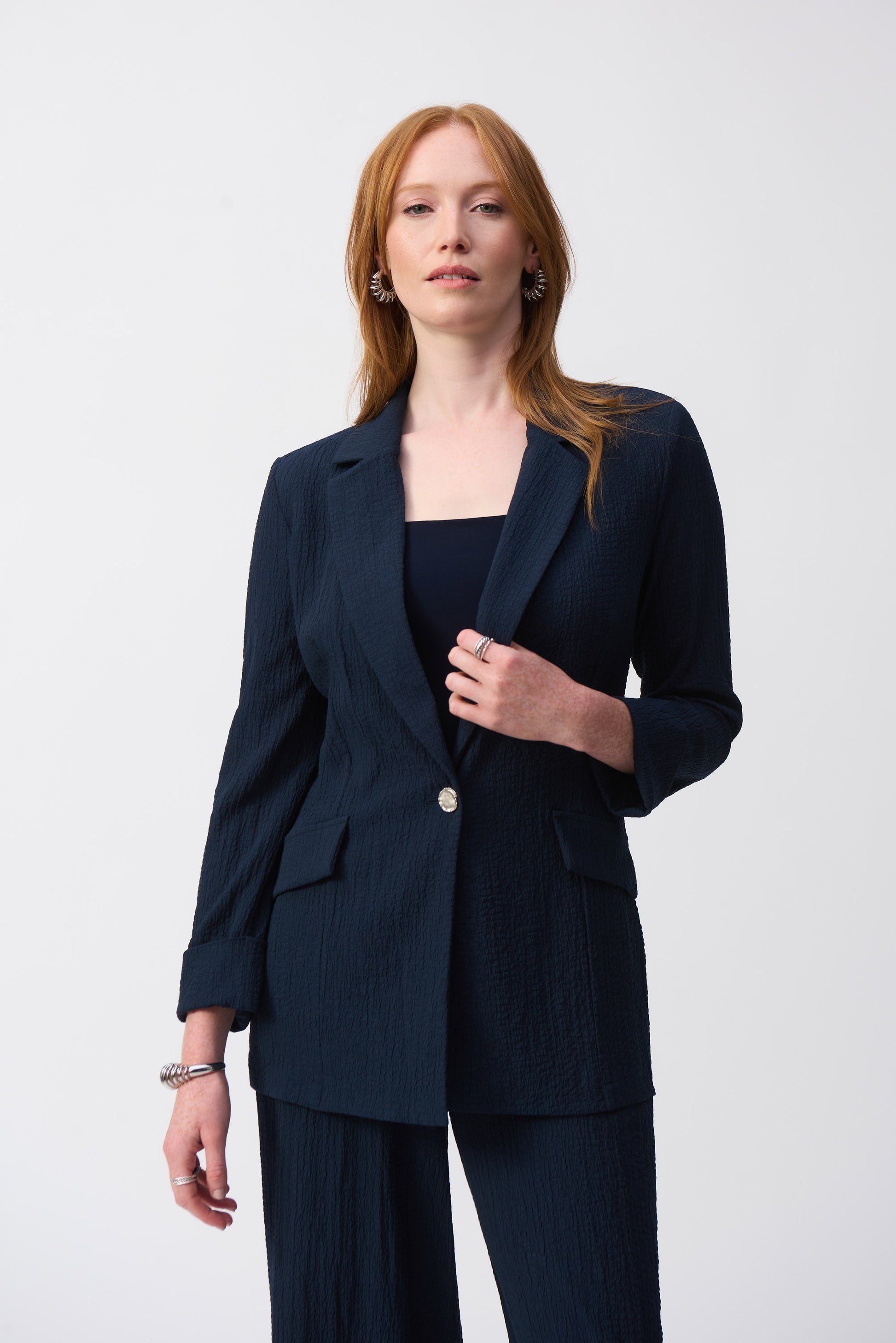 Hannahs Of Erin-Erin Ontario-Joseph Ribkoff-Textured Woven Blazer -Style 251082.colour midnight(navy) A tailored blazer with a refined textured fabric, notched collar, metallic single-button closure, and faux pocket flaps. Features three-quarter sleeves with folded cuffs and a straight silhouette. Available in the Spring 2025 Collection. Pair with matching trousers (Style 251293) for a polished look.







