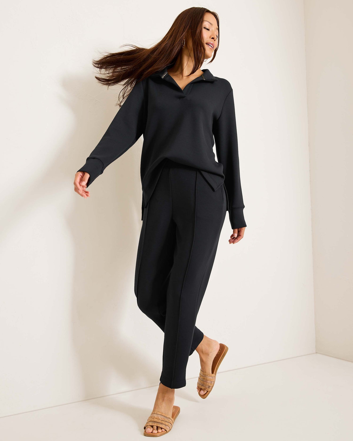 Hannahs Of Erin - Erin Ontario-Tommy Bahama Palm Voyage Sweatshirt- Style#SW221982 colour Black. Featuring a relaxed popover collar, made from ultra-lightweight spacer fabric with 4-way stretch for a smooth, comfortable feel. Ideal for travel, it pairs perfectly with the matching Palm Voyage Pintuck Pants for a chic look from plane to patio. Made with 51% recycled polyester, 44% TENCEL™ Modal, and 5% spandex, combining style and comfort seamlessly.