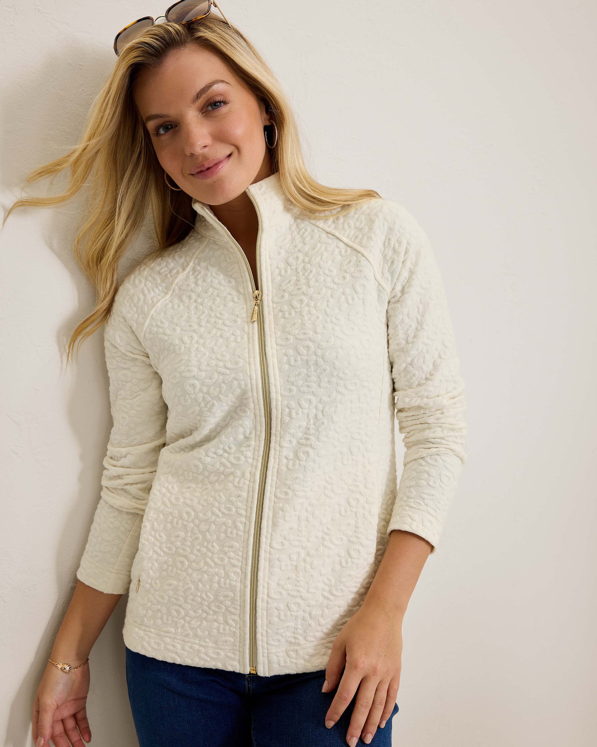 Hannahs Of Erin- Erin Ontario-Tommy Bahama -Aruba Sweatshirt- Style # SW222047  colour coconut (off white) featuring a zip-up design, mock neckline, and zippered pockets, adorned with a jacquard animal print. Made from a blend of 63% cotton, 35% recycled polyester, and 2% spandex, this sweatshirt offers a touch of stretch for comfort. An eco-friendly and stylish choice, perfect for all-day wear.